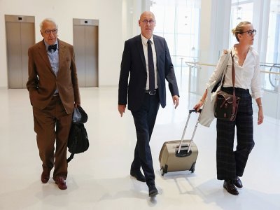 Le président de la Fédération française de rugby Bernard Laporte (C), flanqué des avocats français Jean-Pierre Versini-Campinchi (G) et Fanny Colin (D) arrive au tribunal des Batignolles, le 7 septembre 2022 - Thomas SAMSON [AFP]