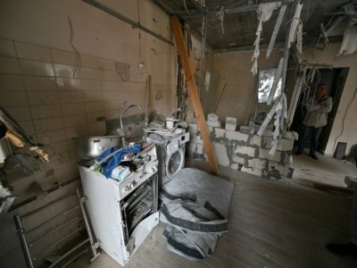 Un homme se tient dans la pièce d'une habitation en grande partie détruite par les combats, le 16 septembre 2022 à Irpin, ville en banlieue de Kiev - Sergei SUPINSKY [AFP]
