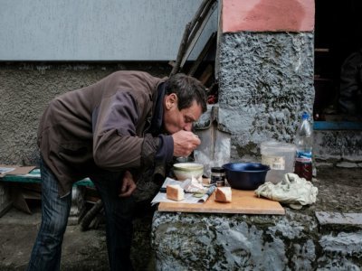 Un homme fait à manger devant son domicile privé d'eau, de gaz et d'électricité dans la ville ukrainienne de Koupiansk (est), le 24 septembre 2022 - Yasuyoshi CHIBA [AFP]