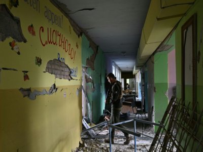 Un militaire ukrainien marche dans un établissement scolaire détruit par les combats dans la région de Mykolaïv, dans le sud de l'Ukraine, le 24 septembre 2022 - Genya SAVILOV [AFP]