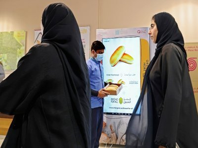 Un homme (c) tient une boîte obtenue à un distributeur de pain gratuit, le 22 septembre 2022 à Dubaï, aux Emirats arabes unis - Karim SAHIB [AFP]