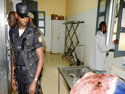 Un policier regarde le corps d'une personne morte durant le massacre du 28 septembre 2009, à la morgue de Conakry, le 1er octobre 2009 - Seyllou [AFP/Archives]