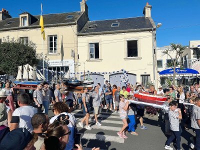 La procession en hommage aux marins disparus. Chaque gerbe porte le nom d'un bateau. 