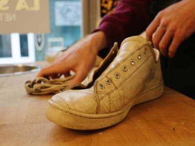 Avant de passer à l'étape du nettoyage, le spécialiste retire les lacets puis examine chaque chaussure une à une. L'objectif : déterminer quelles seront les prochaines étapes de la restauration.