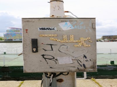 Barbichette, c'est le nom de cet artiste rouennais qui colle des lettres de scrabble sur différents supports. Cette œuvre se trouve près de L'Entrepôt à Rouen. L'artiste assemble des mots qu'il sème à divers endroits dans la ville.