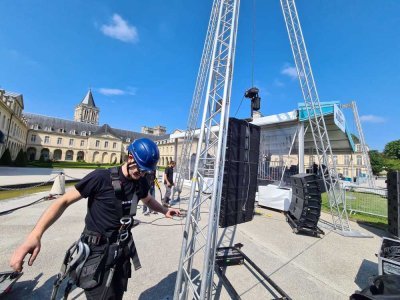 Des agents techniques grimpent à 10,50m de haut pour installer les enceintes. 