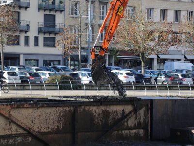 La pelleteuse déverse les sédiments récupérés sous l'eau, dans une barge.