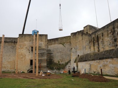 Une grue permet de faire passer les éléments de la rue à l'enceinte du château, en passant par-dessus la muraille.