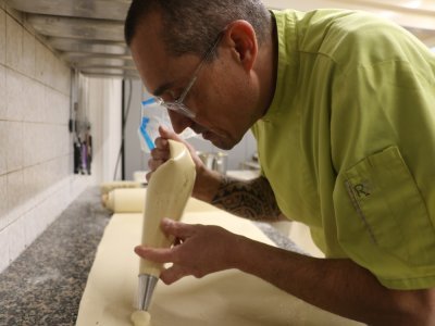 Après avoir utilisé un emporte-pièce, le boulanger-pâtissier a ensuite pu mettre dans sa poche à douille sa crème d'amande. Il peut ensuite pocher sa crème sur chaque canard prédessiné en amont, grâce à l'emporte-pièce.