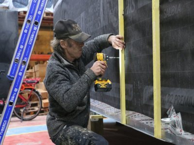 Une fois les ossatures assemblées, l'isolation, le pare-vapeur et le pare-pluie posés ainsi que le plancher, il faut poser le bardage extérieur. Cela ressemble à des tasseaux de bois sur lesquels des planches seront fixées.