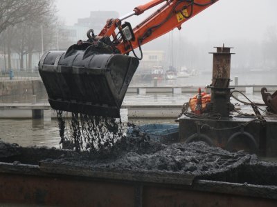 Le dragage du port de Caen est réalisé par une grande pelleteuse.