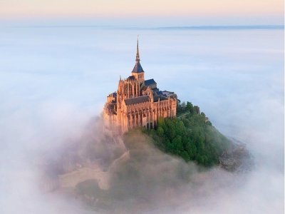 Suspendu à un parapente, le photographe capture les merveilles de la Manche. Ici, le Mont Saint Michel sous la brume.  - Jérôme Houyvet