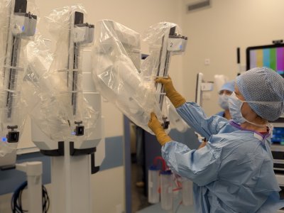 Avant l'opération, l'infirmière de bloc prépare le robot en entourant notamment chaque bras d'un sachet stérile. - Tendance Ouest