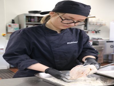 Maëliss Lebel qui est en 1re année de BTS Management hôtellerie-restauration. Elle farine du poulet avant de le cuire dans une casserole afin de les saisir. Puis elle a réalisé un appareil à quiche pour une autre recette. - Justine Carrère