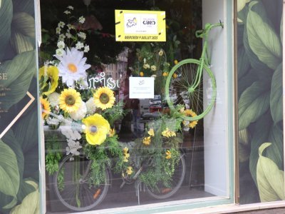 La Ville de Caen propose à ses commerçants un concours afin d'élire la plus belle vitrine décorée à l'occasion du passage du Tour de France, ici Apothéose, un fleuriste situé rue Basse. Le vainqueur est annoncé le 2 juillet. - Lilian Fermin