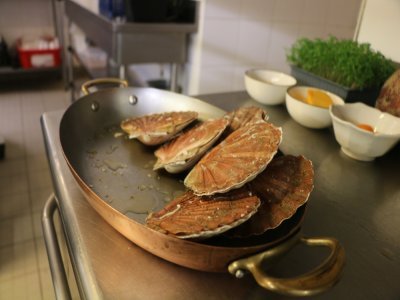 La première étape consiste à ouvrir les coquilles Saint-Jacques. Pour éviter le gaspillage, on récupère les bardes qu'on ajoutera ensuite dans la sauce pour apporter du goût. Il faudra bien rincer la Saint-Jacques.
