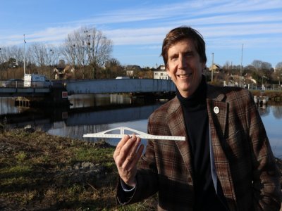 L'architecte, Thomas Lavigne, avec la maquette du nouveau pont entre les mains, devant l'actuel. - L&eacute;o Besselievre
