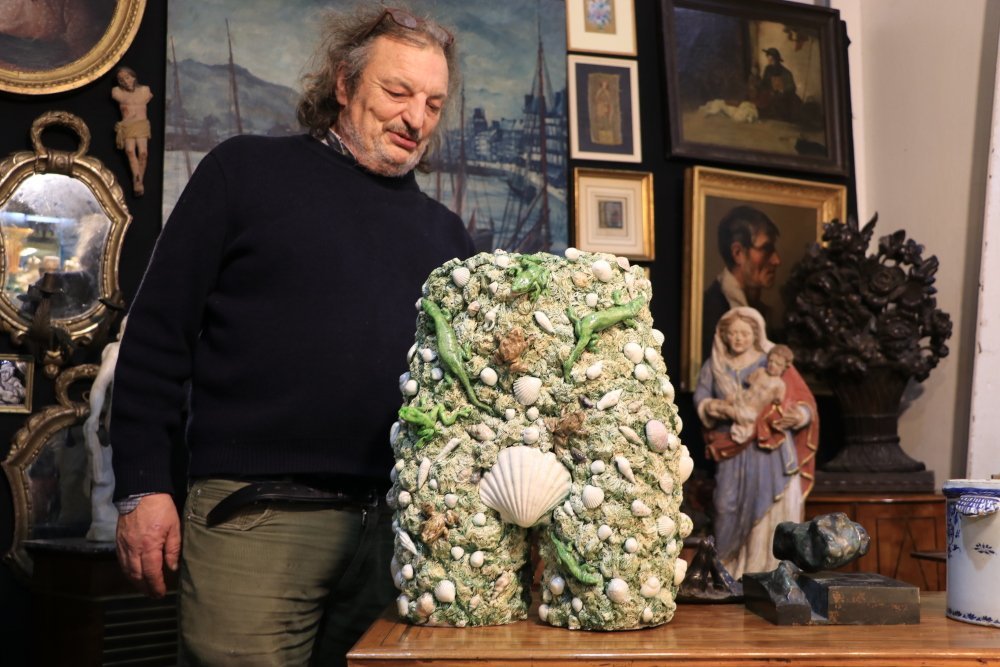 Ce vase, datant du XXe si&egrave;cle, tire son inspiration des c&eacute;ramiques de Palissy avec les l&eacute;zards qui grouillent dessus, mais il est trait&eacute; de mani&egrave;re surr&eacute;aliste. Un clin d'&oelig;il &eacute;galement &agrave; "La Naissance de V&eacute;nus" de Sandro Botticelli.