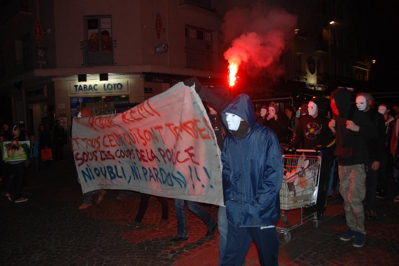 Masques blancs sur le visage, les manifestants défilent.